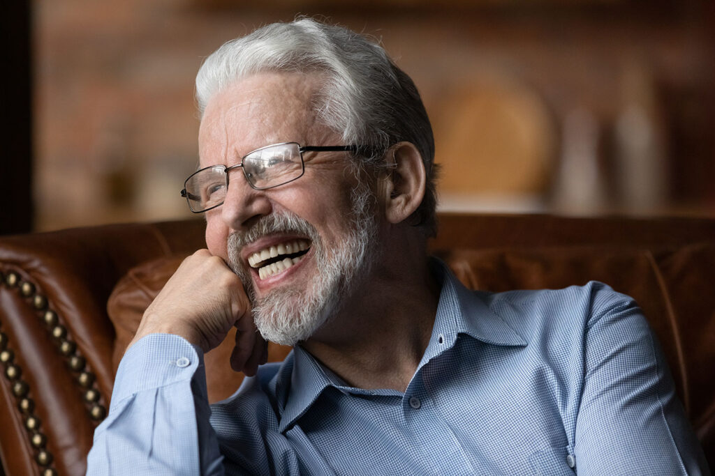 Smiling patient showing natural looking modern dentures